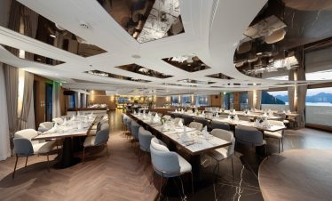 Luxurious waterfront banquet hall with elegant dining setup and panoramic sea views.