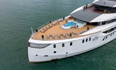 Luxurious yacht deck with a hot tub and sun loungers on the ocean.
