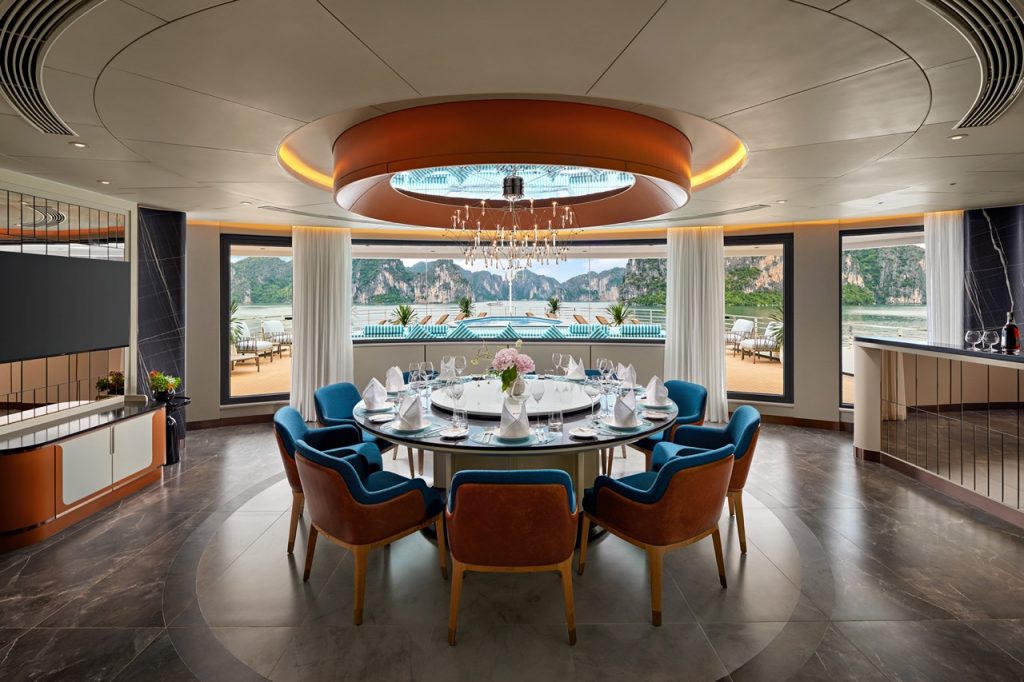 Luxury waterfront dining room with elegant table setting and scenic ocean view.