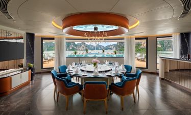 Luxury waterfront dining room with elegant table setting and scenic ocean view.