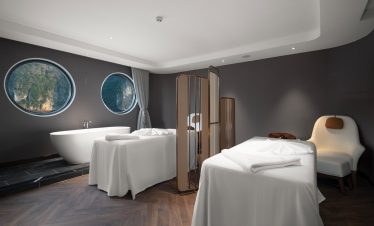 Luxurious spa hotel room with modern decor and panoramic mountain views.