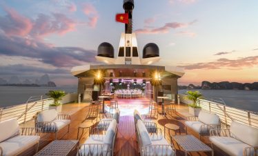 Luxurious yacht deck with sunset view in Vietnam, perfect for exclusive cruises and events.
