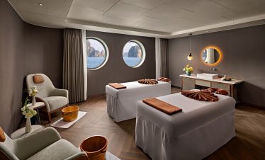 Luxurious spa room with ocean view, relaxing massage beds, modern decor, and tranquil ambiance for wellness retreats.