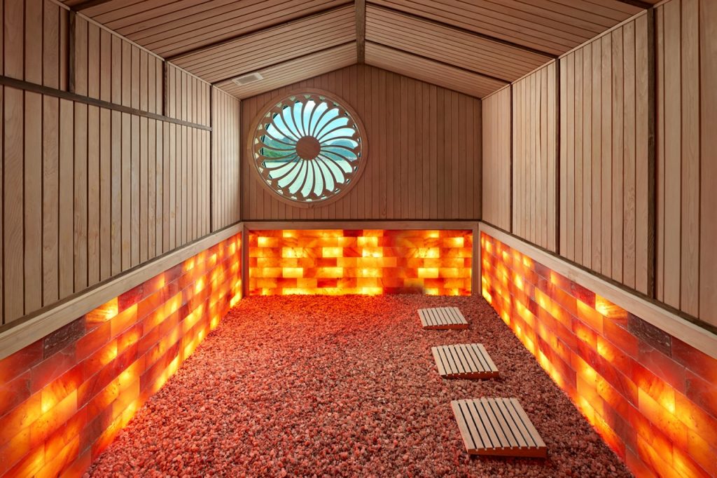 Salt room therapy spa with Himalayan salt bricks and wooden decor for relaxation and wellness.