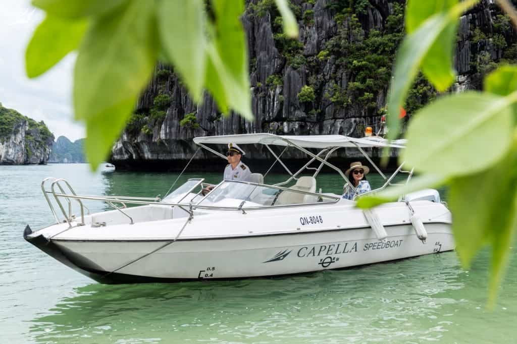 Relaxing speedboat tour in Ha Long Bay with scenic limestone cliffs, ideal for luxury travel.