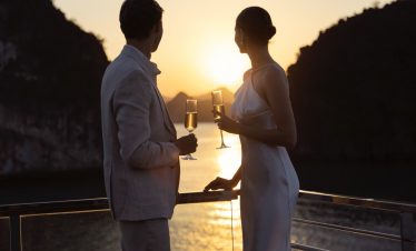 Romantic couple at sunset enjoying champagne on a cruise in Vietnam, honeymoon, Love, luxury travel.