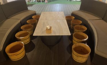 Soaking Tub Buckets for Fruit Bath, Rattan Sofas, and Marble Table at ViettrendTour Restaurant.