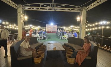 Relaxing night dinner on a rooftop with string lights in Vietnam, perfect for travel and tour experiences.