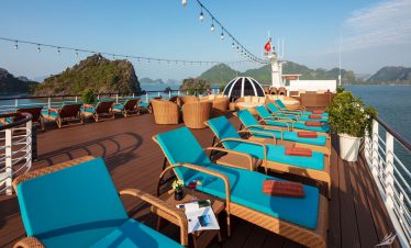 Relaxing cruise deck with sun loungers overlooking Halong Bay, Vietnam.