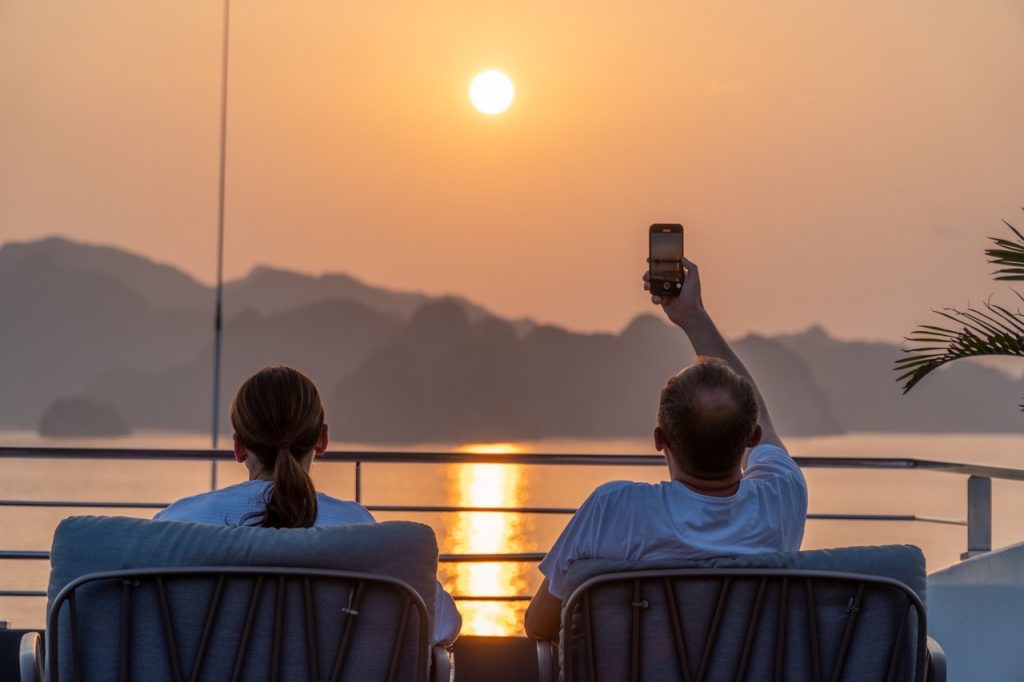 Relaxing sunset cruise in Vietnam with stunning mountain views, perfect for travel enthusiasts.