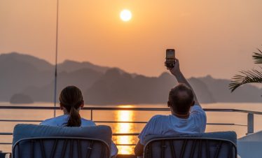 Relaxing sunset cruise in Vietnam with stunning mountain views, perfect for travel enthusiasts.
