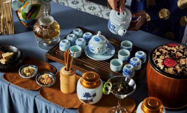 Elegant traditional Vietnamese tea setting with blue and white porcelain, tea and snacks.