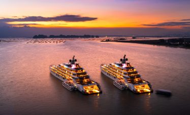Luxury yachts at sunset in Ha Long Bay, Vietnam, scenic cruise, tropical vacation, boat tour.
