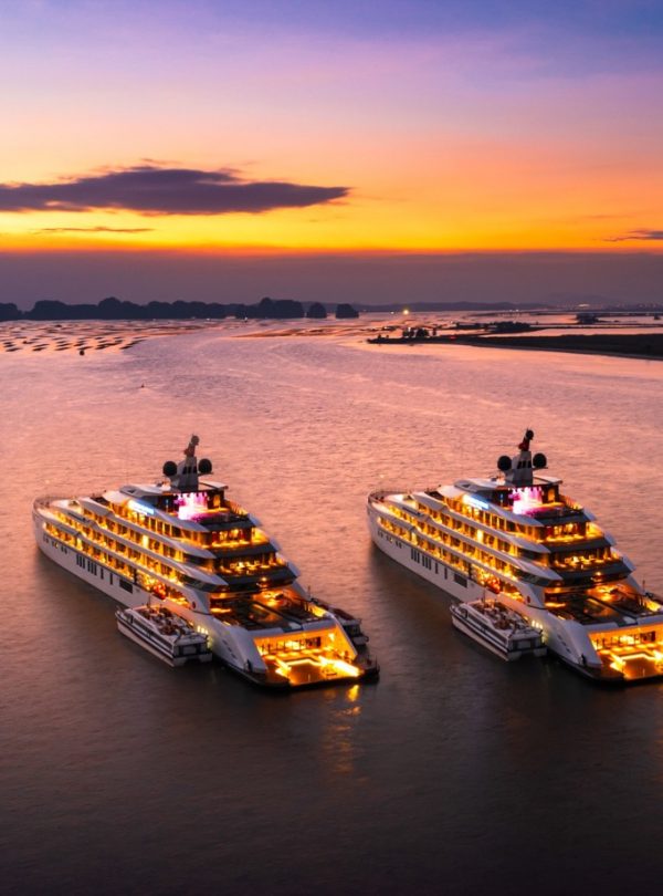 Luxury yachts at sunset in Ha Long Bay, Vietnam, scenic cruise, tropical vacation, boat tour.