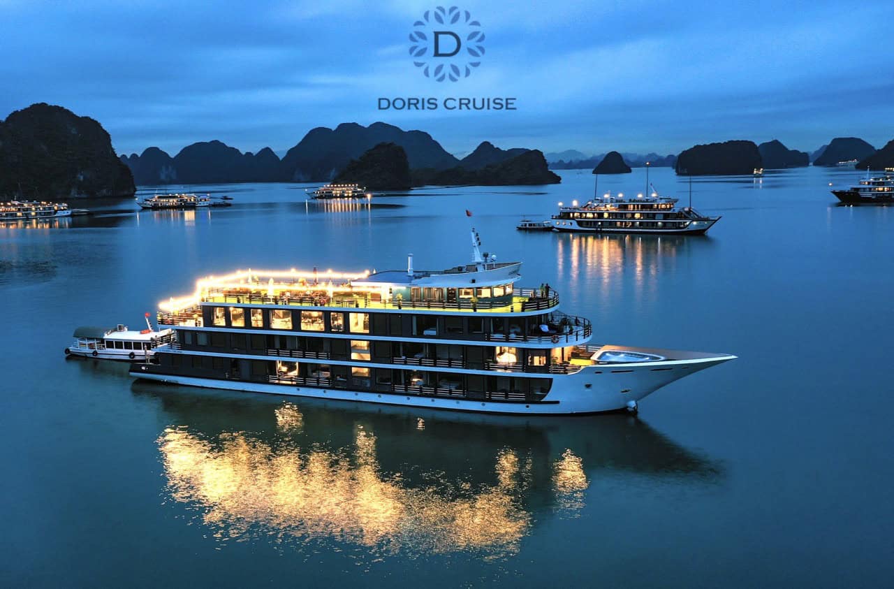 Stunning Halong Bay cruise ship at sunset with karst formations in the background.