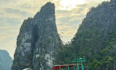 Stunning limestone karst landscape with boats on emerald water in Halong Bay, Vietnam.