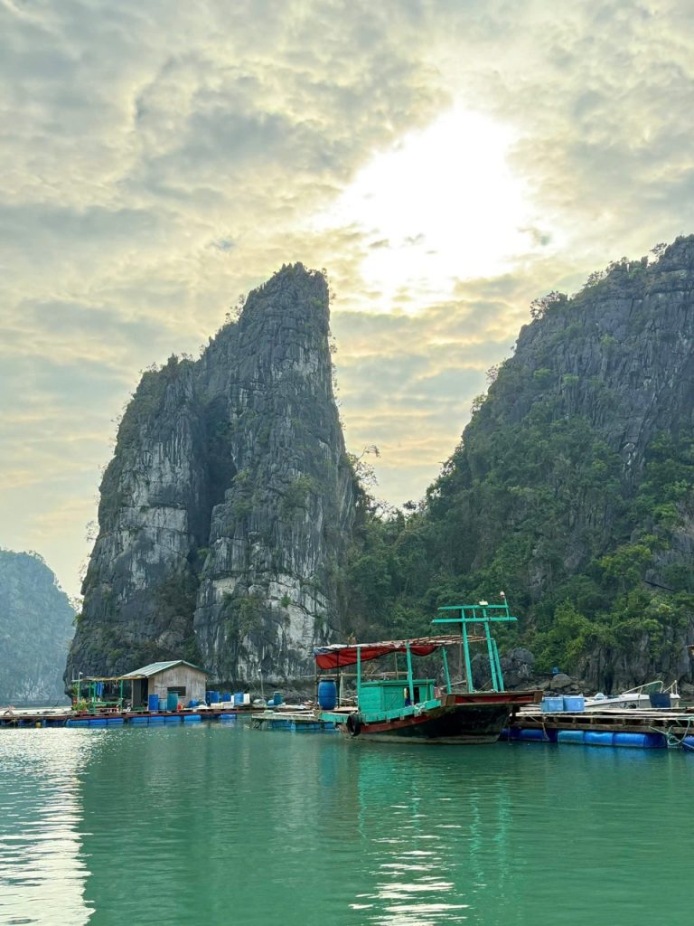 Stunning limestone karst landscape with boats on emerald water in Halong Bay, Vietnam.