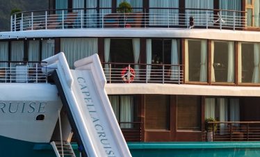 Luxury cruise yacht in Ha Long Bay, Vietnam with outdoor deck and water slide.