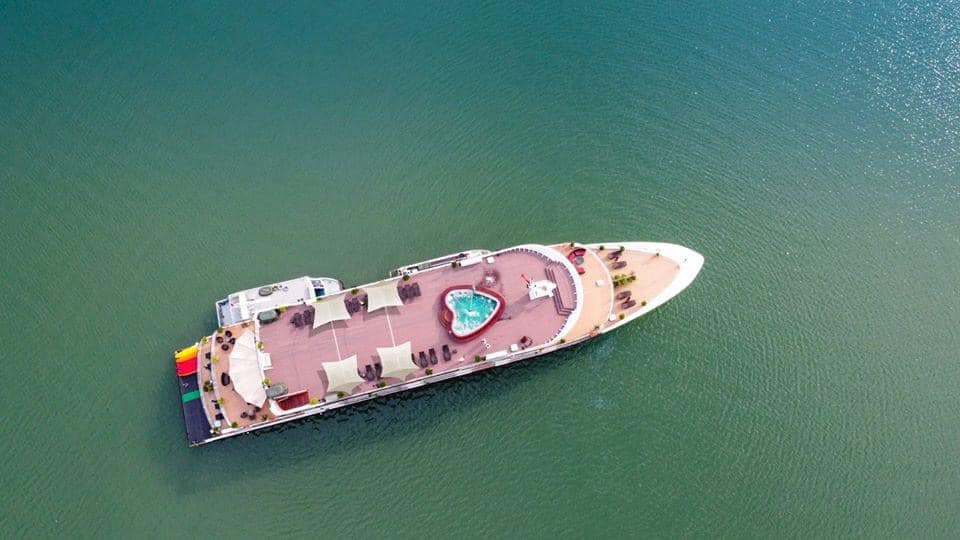 Luxury yacht with a pool on the deck in emerald green waters.