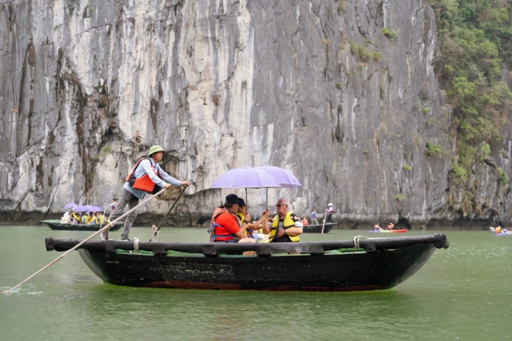 Serene boat tour on Halong Bay with limestone cliffs and emerald waters, perfect for travelers seeking adventure and nature.
