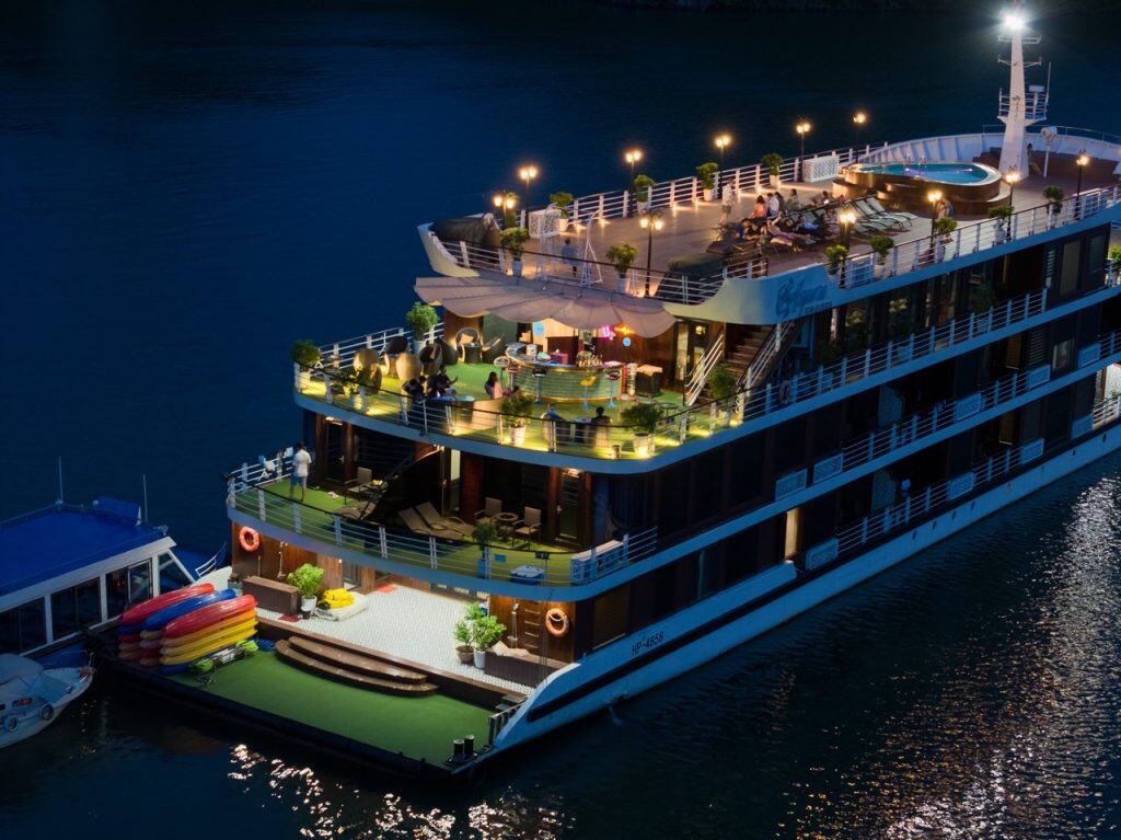 Luxurious dinner cruise boat on the river at night with scenic lighting and outdoor deck, Vietnam travel experience.