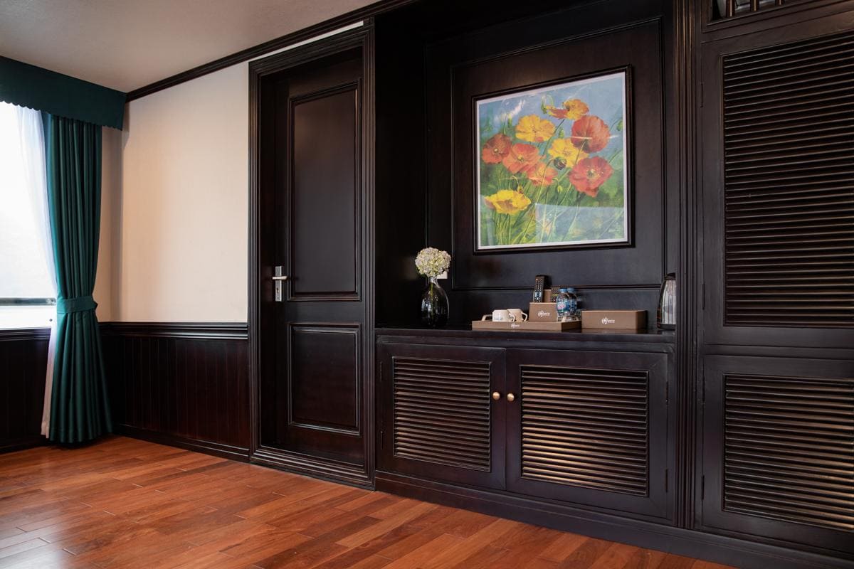 Elegant hotel interior with dark wood paneling and a colorful floral painting.