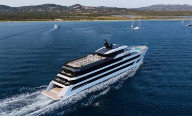 Luxurious yacht cruising in pristine blue waters with scenic coastline background.