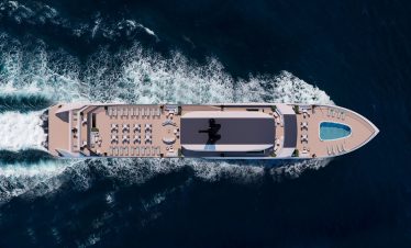 Luxury cruise yacht with outdoor sunbathing deck and swimming pool in the open sea.