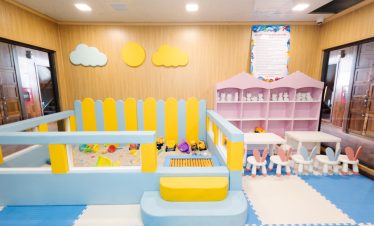 Colorful indoor children's play area with toys, soft flooring, and playful decor for kids' fun.