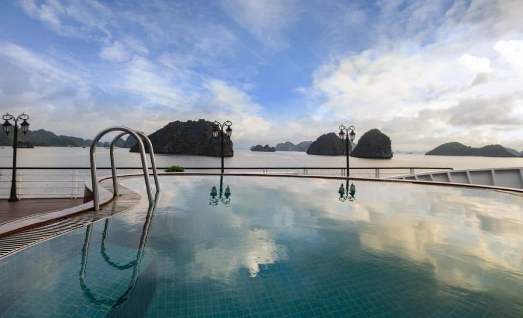 Stunning infinity pool overlooking Halong Bay with limestone islands, perfect for luxury Vietnam travel.