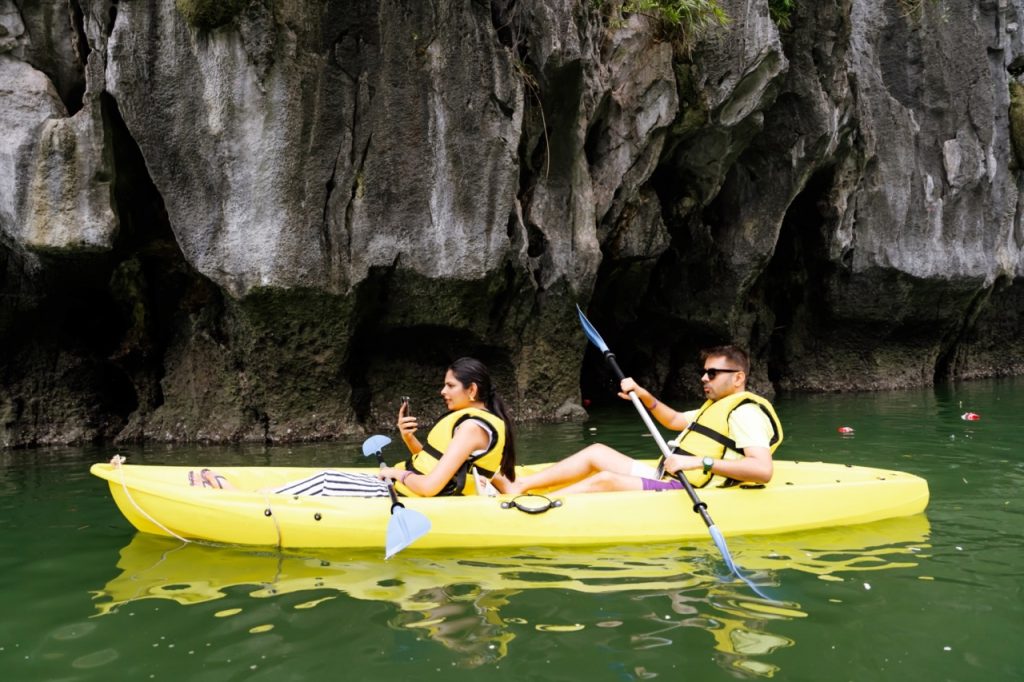 Serene kayak adventure along limestone karsts in Vietnam's scenic landscape.