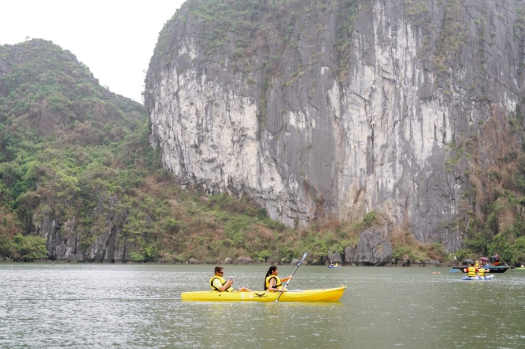 1. People kayaking in Halong Bay with stunning limestone karsts and emerald waters.