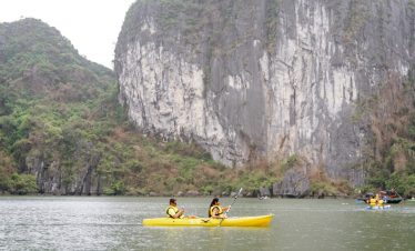 1. People kayaking in Halong Bay with stunning limestone karsts and emerald waters.