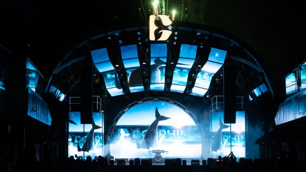 Whale-themed stage at Vietnam nightlife event with vibrant lights and performances.