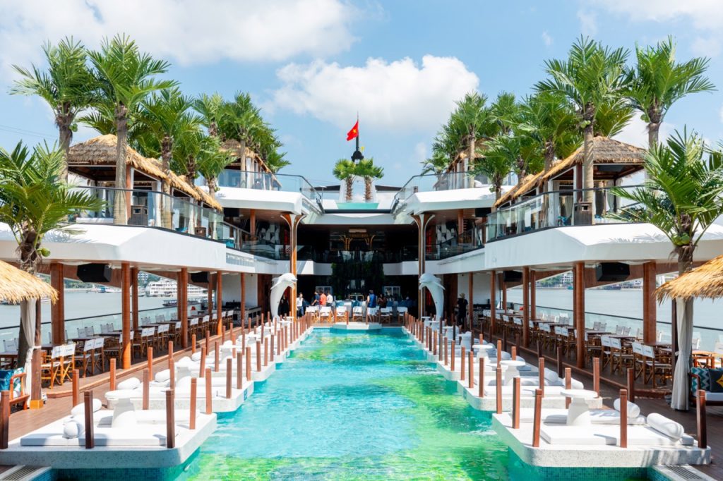 Luxurious waterfront resort with pools, palm trees, and ocean views in Vietnam.