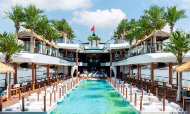 Luxurious waterfront resort with pools, palm trees, and ocean views in Vietnam.