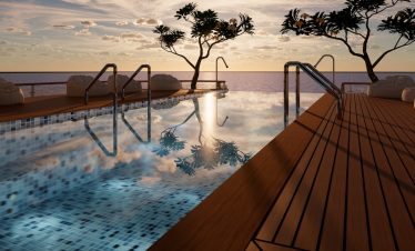 Luxurious infinity pool overlooking ocean at sunset.
