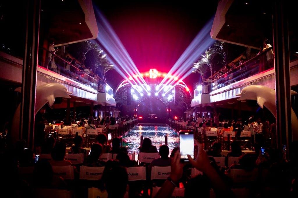 ViettrendTour event with stage lighting, people enjoying concert at night, tropical setting.