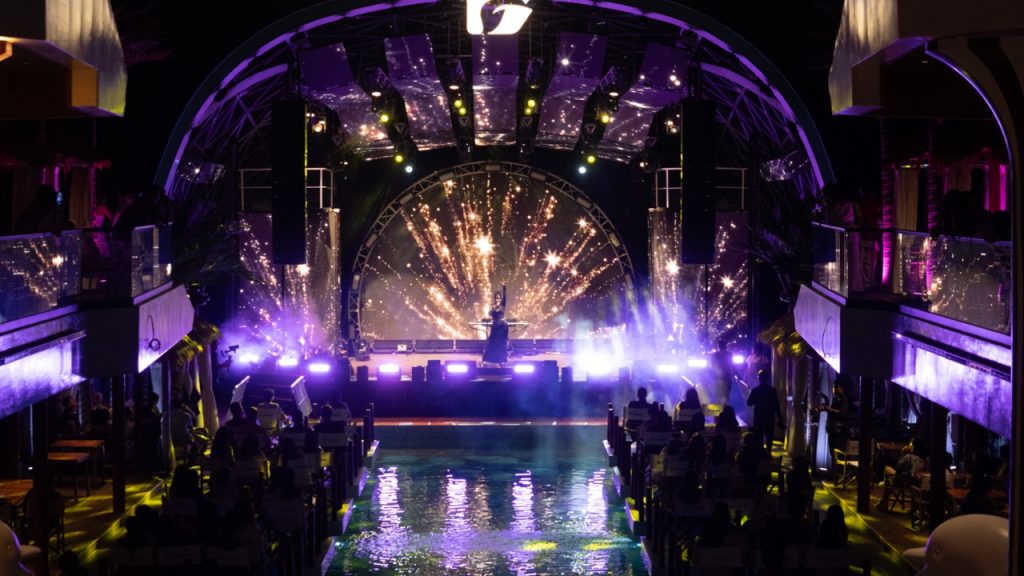 Colorful nightclub stage with vibrant lights and entertainment for tourist celebrations.