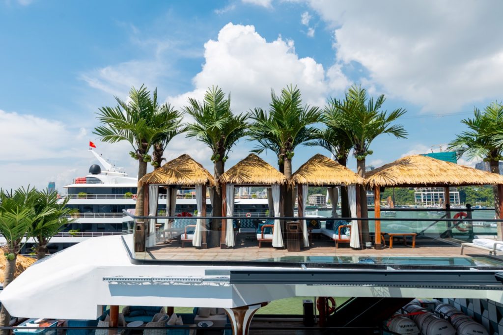 Luxurious yacht deck with tropical cabanas and swaying palm trees, perfect for a vacation in Vietnam.