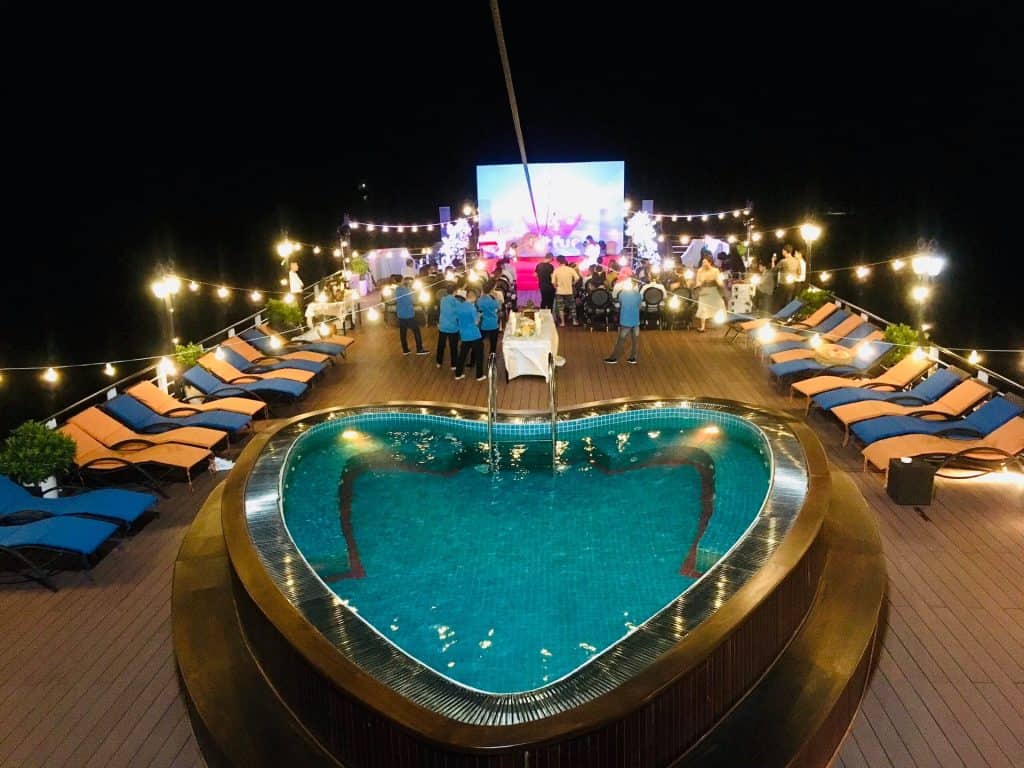 Luxury rooftop party with swimming pool and outdoor entertainment at night, Vietnam tourism.