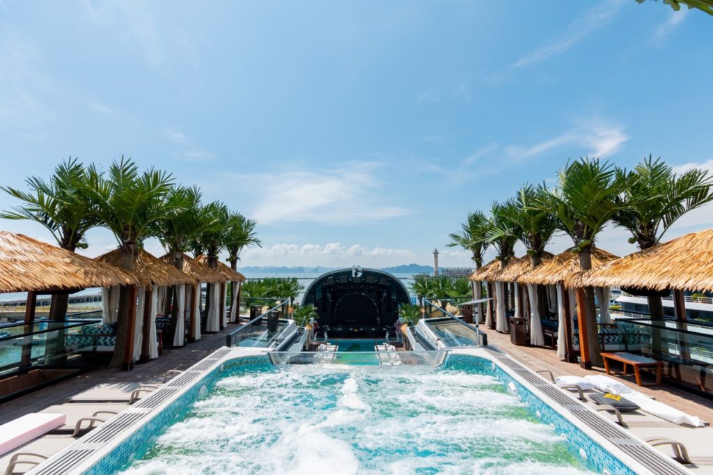Luxurious rooftop infinity pool with tropical cabanas and scenic ocean views.