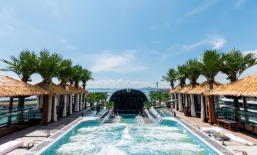 Luxurious rooftop infinity pool with tropical cabanas and scenic ocean views.