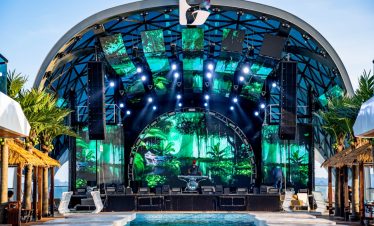 ViettrendTour, tropical outdoor concert stage with vibrant LED screens and lush greenery backdrop.