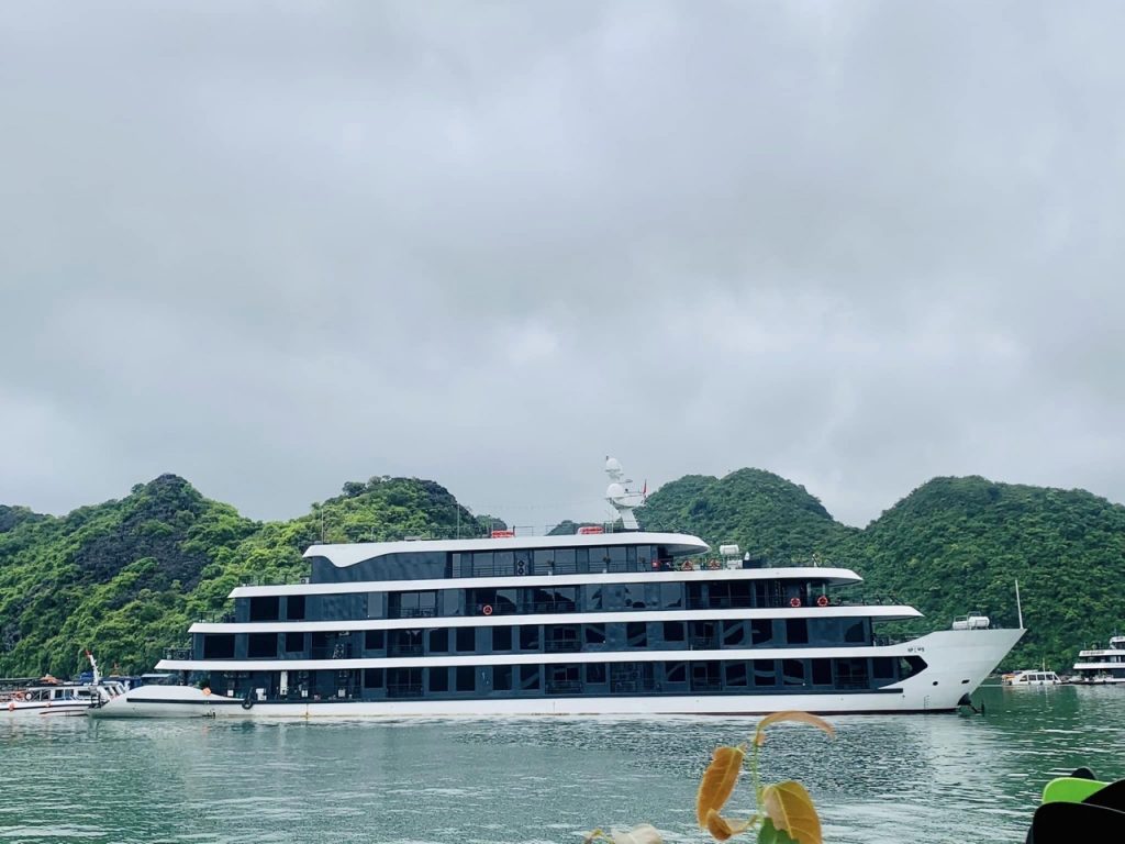 Lan Ha Bay Cruise 1 night - Luxury cruise ship on Lan Ha Bay with lush green islands in the background.