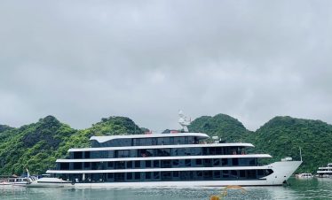 Lan Ha Bay Cruise 1 night - Luxury cruise ship on Lan Ha Bay with lush green islands in the background.