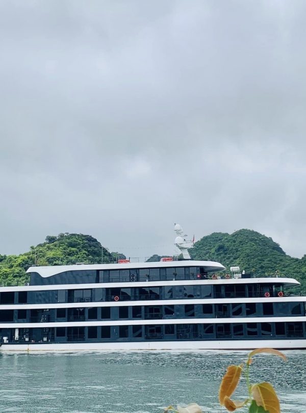 Lan Ha Bay Cruise 1 night - Luxury cruise ship on Lan Ha Bay with lush green islands in the background.