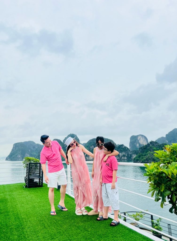 Scenic Lan Ha Bay cruise balcony with family, lush green islands, and calm waters, perfect for a rel.