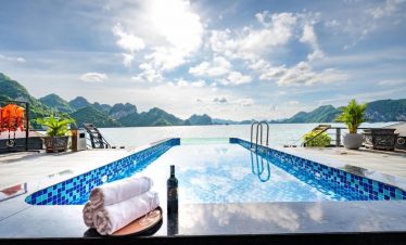Relaxing pool on Lan Ha Bay cruise with mountain views and clear blue sky, perfect for a tranquil ge.