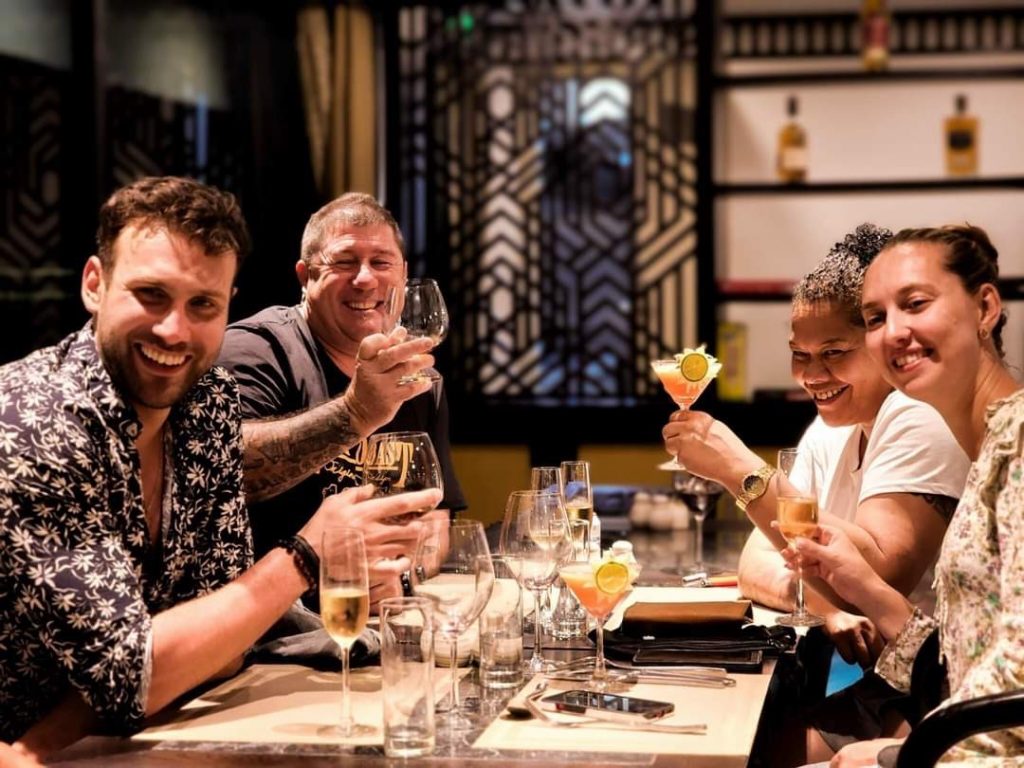 Enjoying a luxurious cruise dinner in Halong Bay with friends, scenic views, and celebratory drinks.
